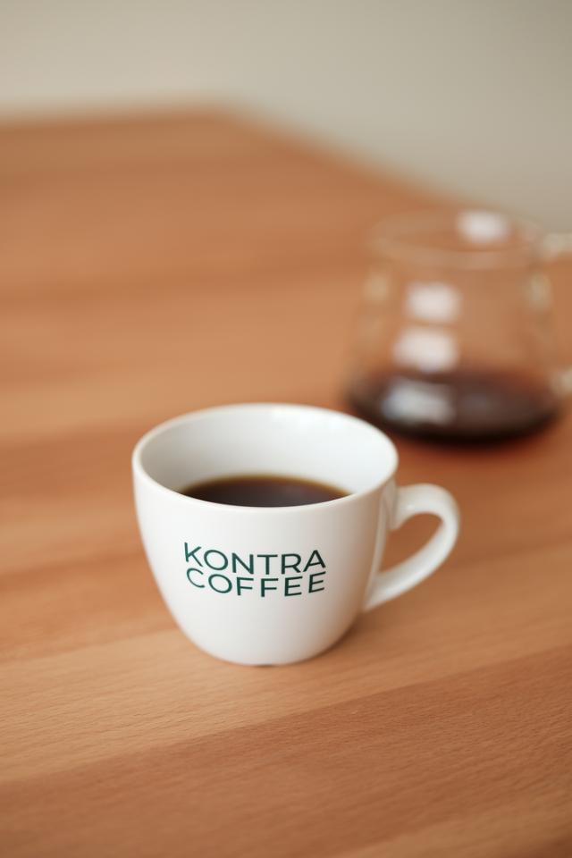 kaffekop med kontra coffee logo hario glaskande med kaffe i baggrunden