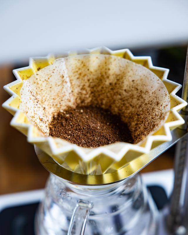 formalede kaffeboenner i gul origami filterholder ovenpaa hario glaskande